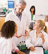A teacher who is taking USD Scientific Discovery Series courses, conducting a science experiment with students in class