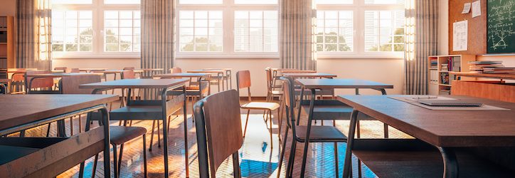 interior of a traditional school classroom with wooden floor and furniture.