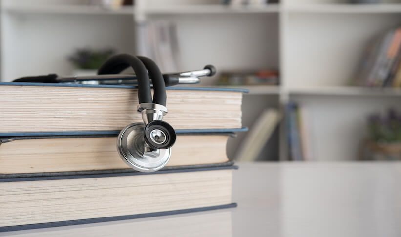 stethoscope-on-stack-of-medical-text-book-on-doctor-desk-at-room-in-hospital.