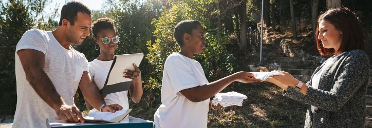 Multicultural group of young volunteers distribute flyers and leaflets in the street for nonprofit marketing