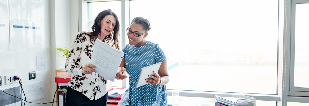 Two female teachers timetable and lesson planning.