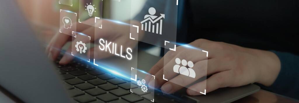 Hands on a laptop keyboard with Ai hologram graphics hovering above keyboard