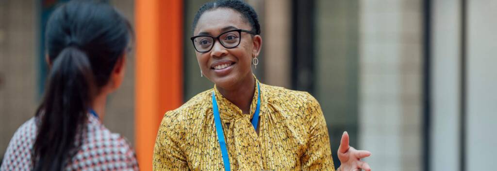 2 educators smiling and speaking